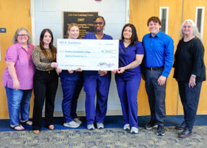 Accepting the donation are PCC Coordinator of Occupational Health Tina Ormond, at left, Nurse Aide I students, from left, Emily Dingess, Shantara Stilley and Adrianna Hamilton, PCC President Zac Schnell, fifth from left, and PCC Chair of Continuing Education and Technical Programs Lori Giles, at right.