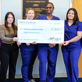 Accepting the donation are PCC Coordinator of Occupational Health Tina Ormond, at left, Nurse Aide I students, from left, Emily Dingess, Shantara Stilley and Adrianna Hamilton, PCC President Zac Schnell, fifth from left, and PCC Chair of Continuing Education and Technical Programs Lori Giles, at right.