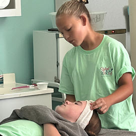 Cosmetology camp student working on a mannequin