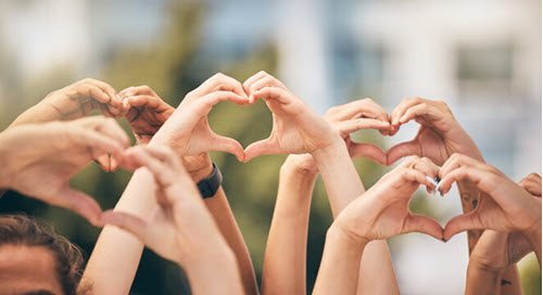Several people making a heart with their hands